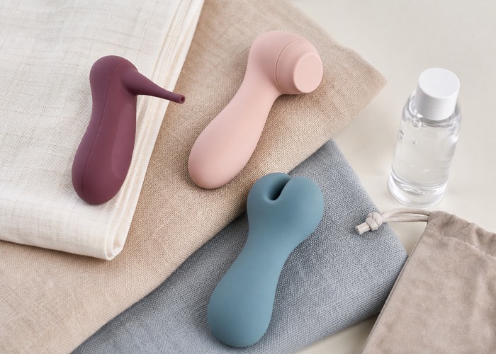 Clitoral Vibrators guide product scene with small wellness device heads, microfiber cloth, toy cleaner bottle
