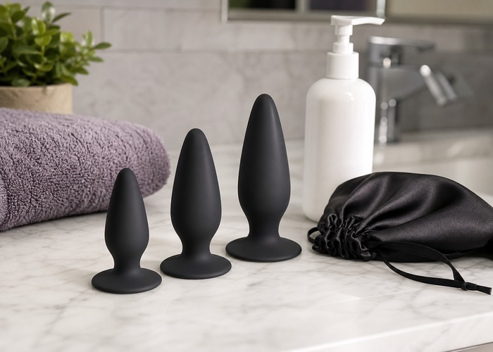 Clean anal toys, soft towel, storage pouch, and mild cleanser arranged on a bathroom counter