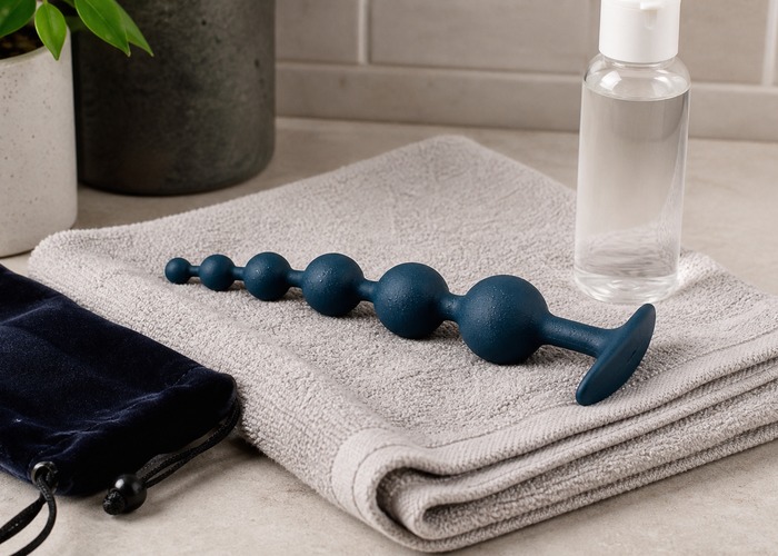 Anal Vibrators product scene showing graduated silicone bead strand, wide flared base, water-based lube